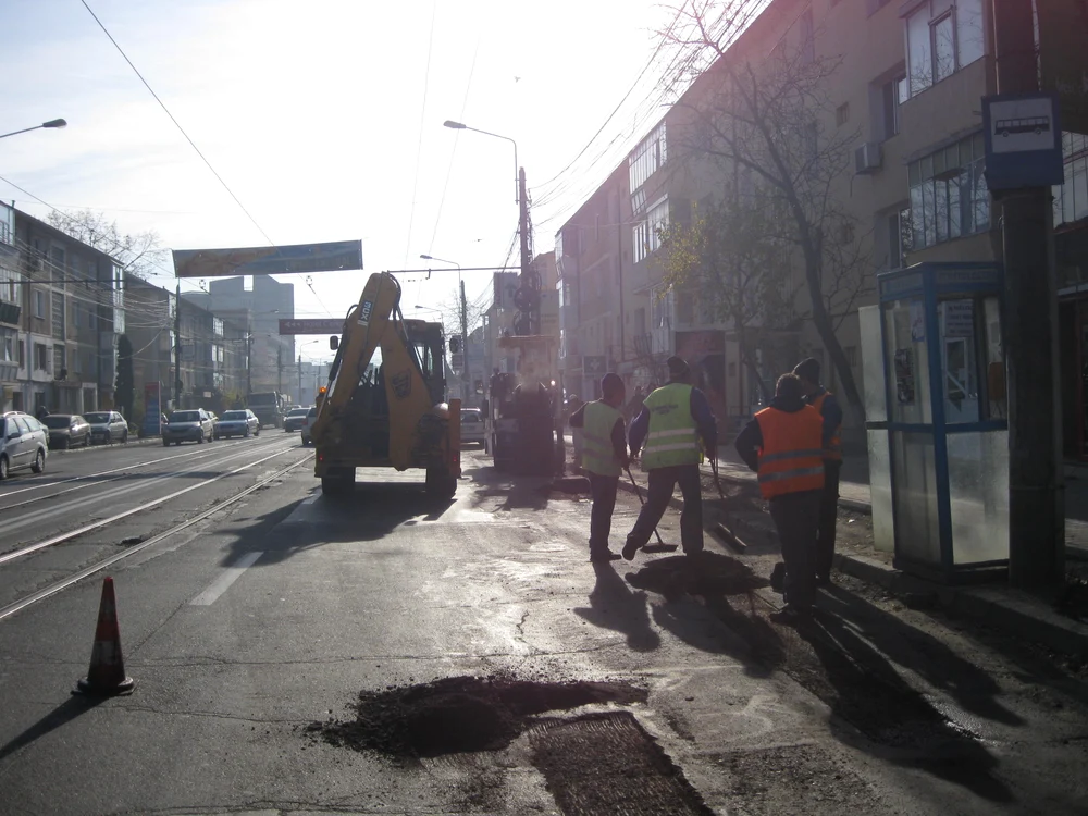 Muncitorii astupă gropile cu asfalt