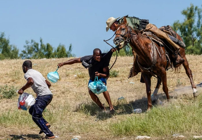 Agenti de poliţie de frontieră din Statelor Unite călare încearcă să opreasca un migranti haitian să intre într-o tabără pe malurile Rio Grande in Del Rio Texas