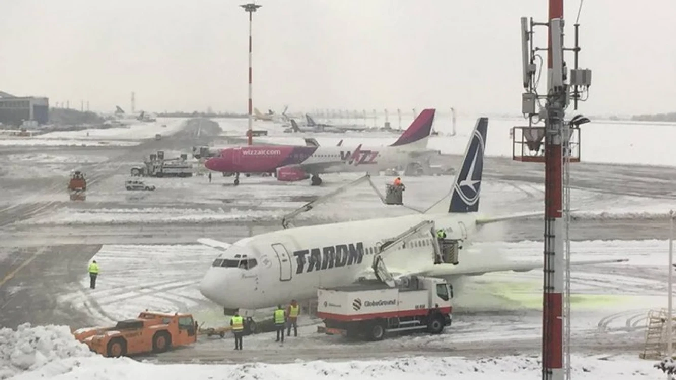 două aeronave pe pista unui aeroport în condiții de iarnă