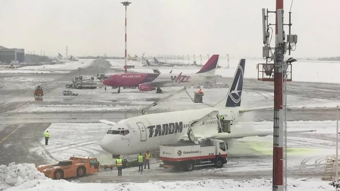 două aeronave pe pista unui aeroport în condiții de iarnă