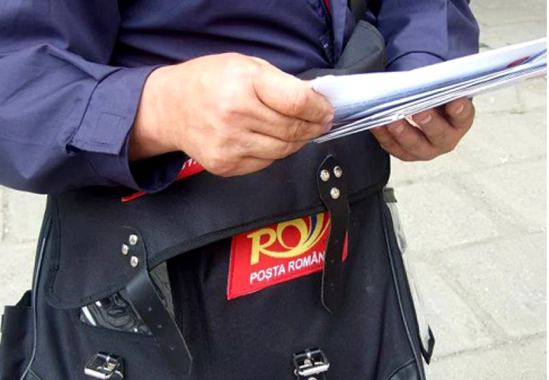 Un poștaș caută deciziile cu noile pensii rezultate în urma recalculării