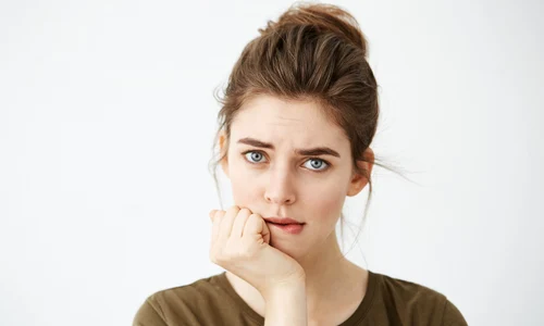 beautiful shy young woman with hair bun thinking biting lip jpg