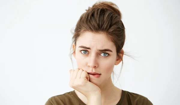 beautiful shy young woman with hair bun thinking biting lip jpg