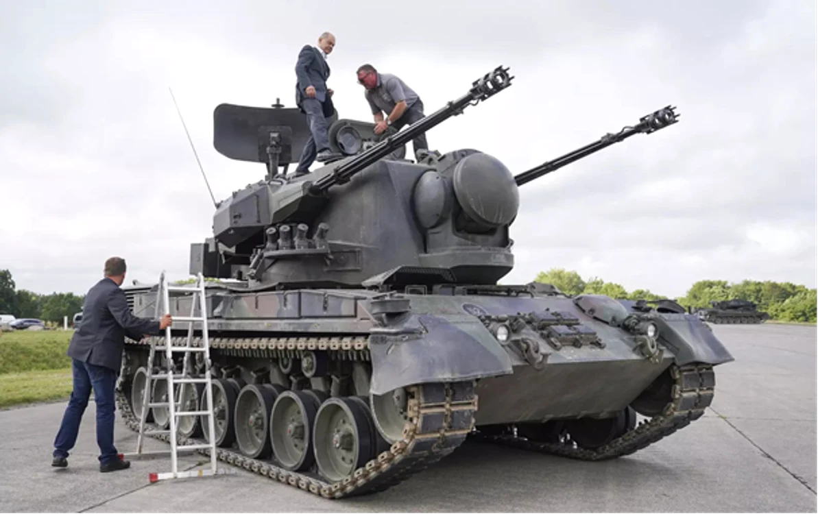 Cancelarul german Olaf Scholz, stânga sus, stă deasupra unui tanc Gepard