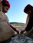 Locuitori din Tolmeita, îmbrăcați în costume tradiționale, joacă un joc pe zidurile Pieței Cisternei din Ptolemais (© Piotr Jaworski)