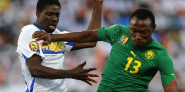 Georges Ambourouet, în echipament alb, în duel cu un camerunez la Cupa Africii 