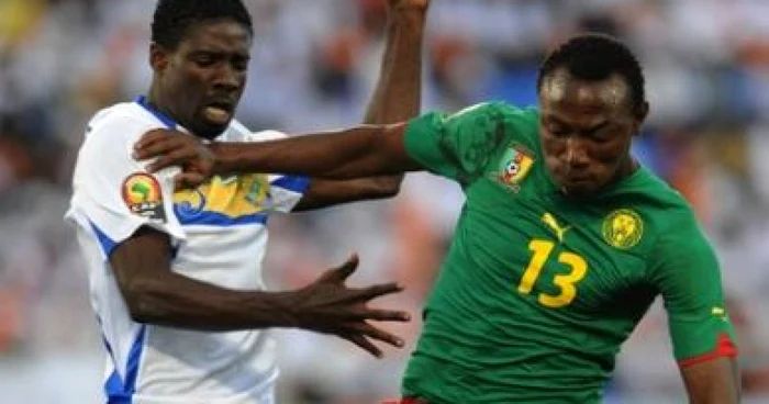 Georges Ambourouet, în echipament alb, în duel cu un camerunez la Cupa Africii 