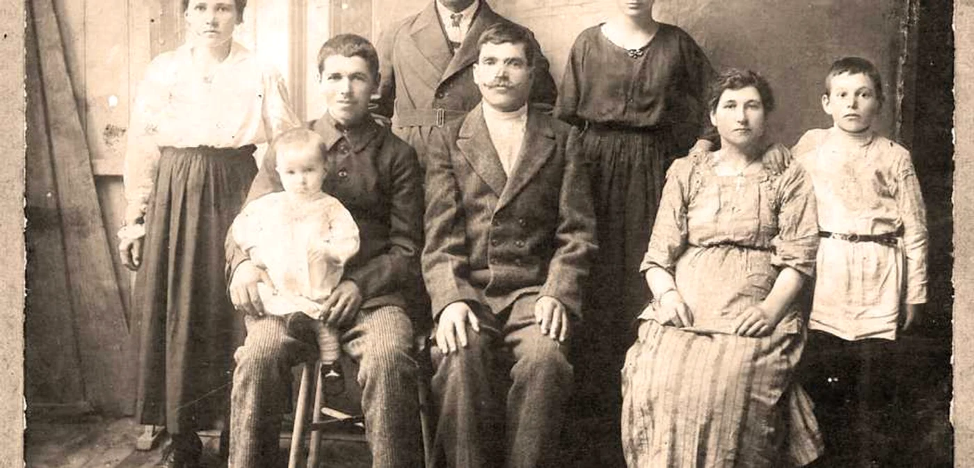 Sofia (prima din stânga, în picioare) şi Pantelei Hadjioglu (în stânga, pe scaun, cu fiul Dumitru în braţe), alături de rude. Anul 1921. FOTO Arhiva pesonală a Mariei Coreţchi, fiica celor doi