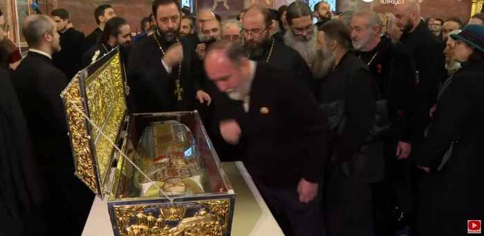 Preoții și mulțimea se închină la moaștele părintelui Dumitru Stăniloae. FOTO captură Trinitas TV