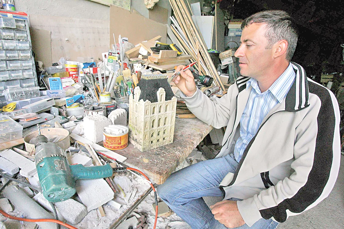 Artistul lucrează  câteva ore pentru a  reproduce o clădire  în miniatură