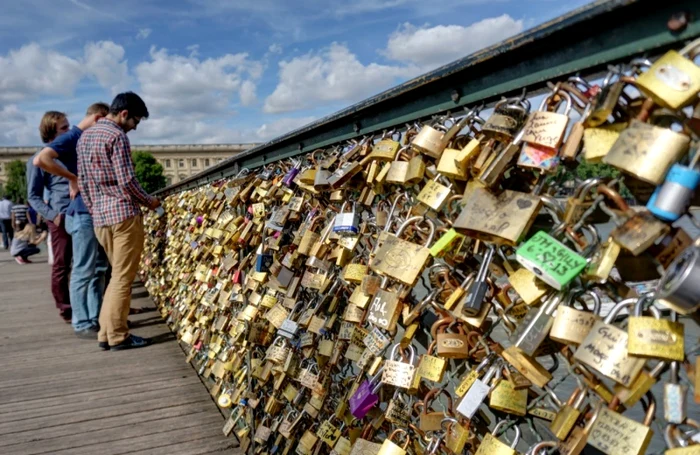 Îndrăgostiţii agaţă lacăte cu numele lor de balustradele podurilor Pont des Arts şi Pont de l’Archevêché din Paris ca dragostea lor să fie eternă