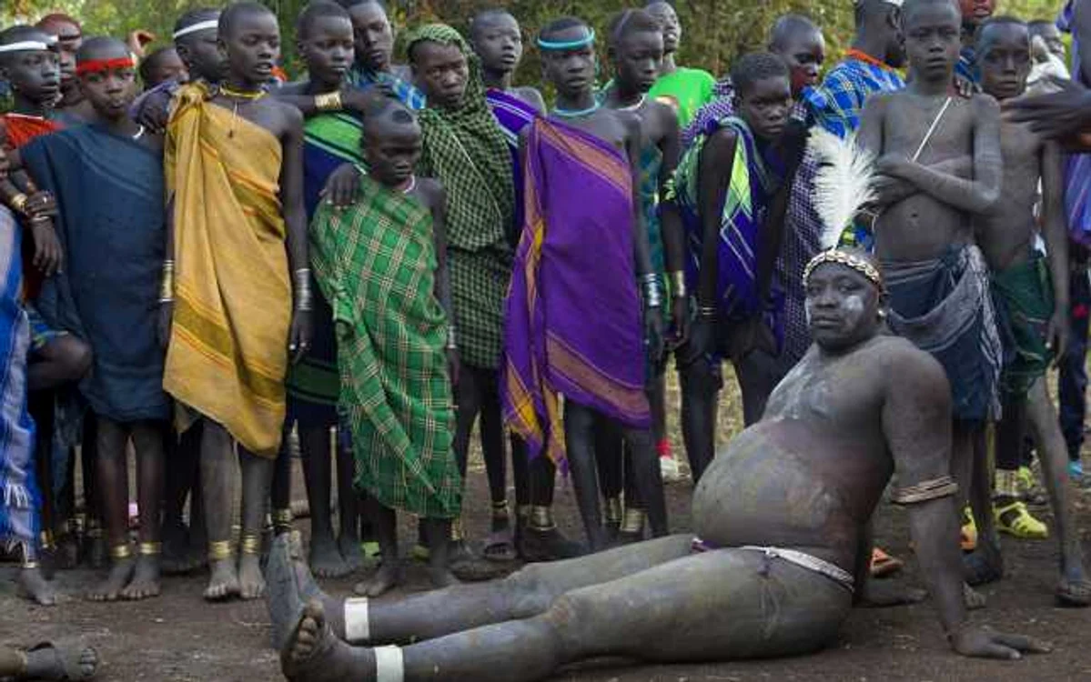 Copii tribului Bodi speră să devină într-o zi asemenea bărbatului din faţa lor, concurent  la una dintre cele mai importante ritualuri ale comunităţii. FOTO: Eric Lafforgue