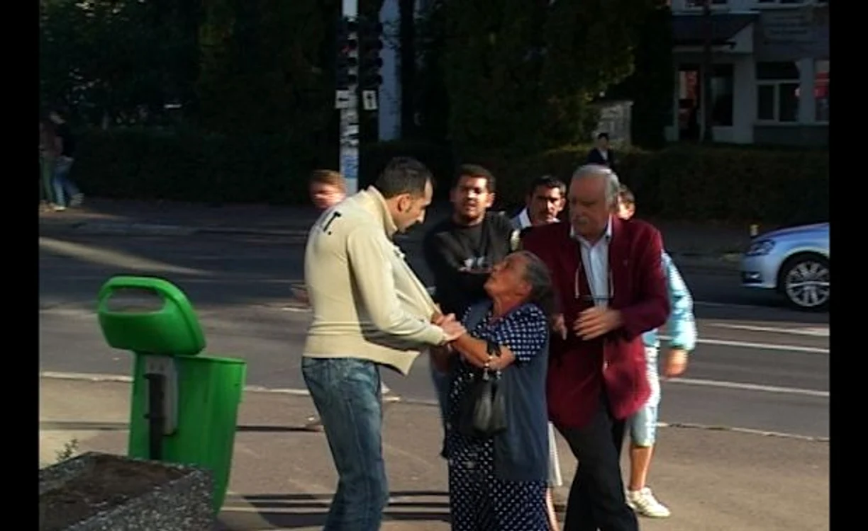
    Constantin Ganea (în sacou roşu), încercând să-l scoată pe fiul său din mâna familiei minorei.  
