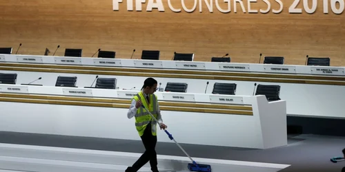 O persoană curăţă scările în timpul congresului extraordinar al FIFA la Zurich Elveţia FOTO AP