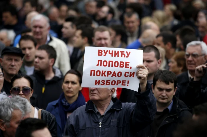 Un protestatar afişează mesajul „Vucici, hooţule, ai furat alegerile”, în timpul unui protest organizat sâmbăta la Belgrad Foto AP