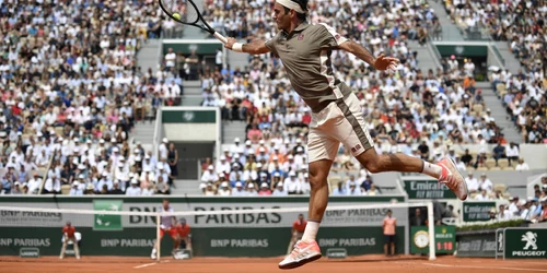 Elveţianul Roger Federer loveşte mingea în partida contra conaţionalului său Stan Wawrinka de la Roland Garros 2019 Paris Fraţa. FOTO EPA-EFE