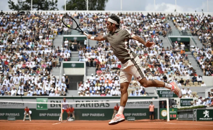 Elveţianul Roger Federer loveşte mingea în partida contra conaţionalului său Stan Wawrinka de la Roland Garros 2019 Paris Fraţa. FOTO EPA-EFE