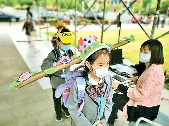 În China, copiii au revenit  la școală cu pălării de distanțare