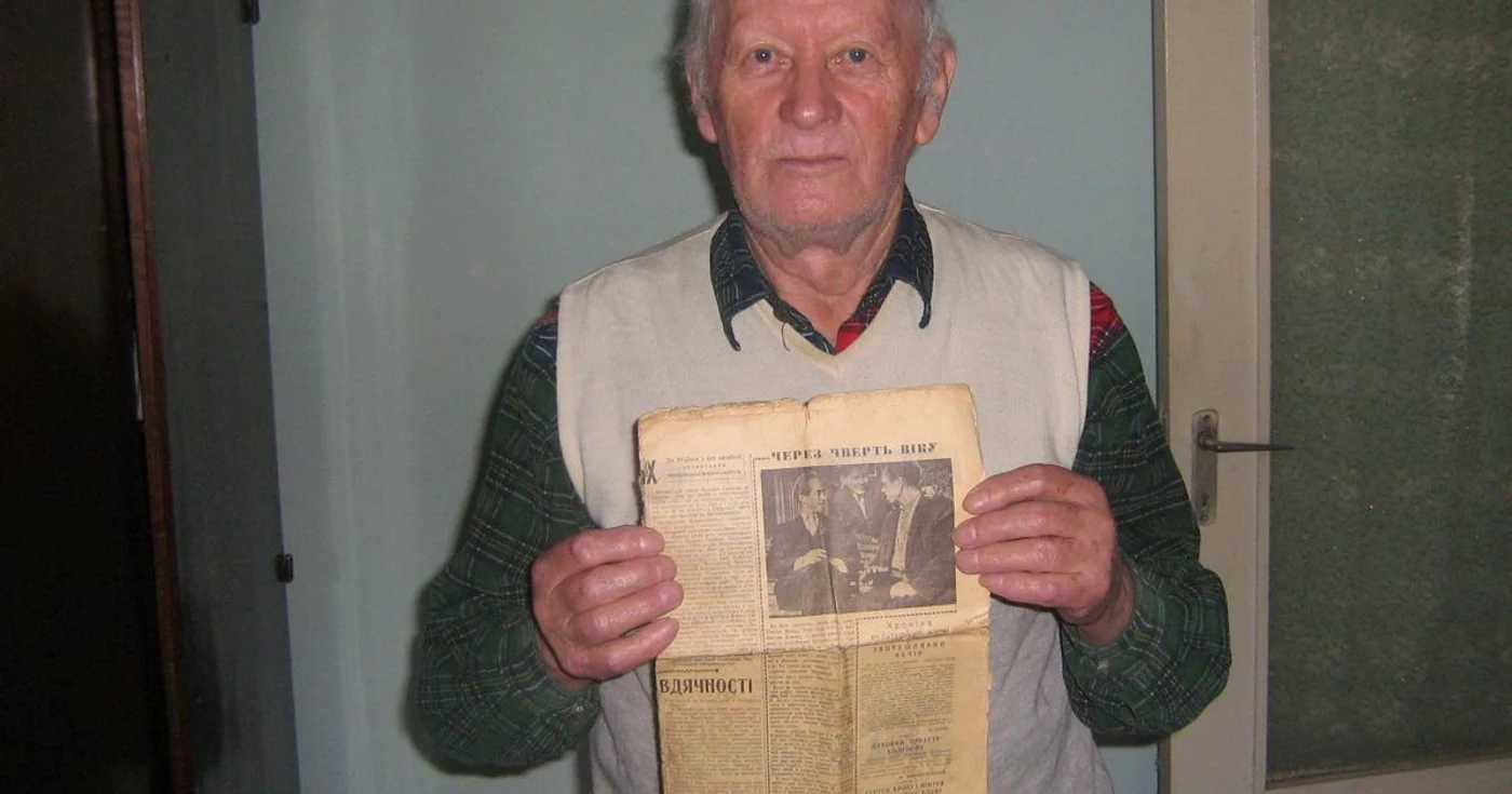 Simion Bilac ține în mână ziarul „Bucovina strămoșească”, unde s-a scris în 1962 despre momentul în care și-a revăzut fratele.