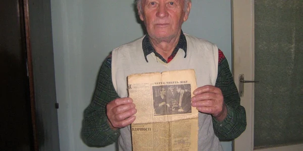 Simion Bilac ține în mână ziarul „Bucovina strămoșească”, unde s-a scris în 1962 despre momentul în care și-a revăzut fratele.