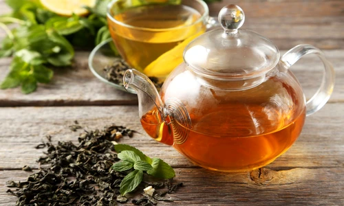 35165543   cup with green tea and teapot on grey wooden background jpeg
