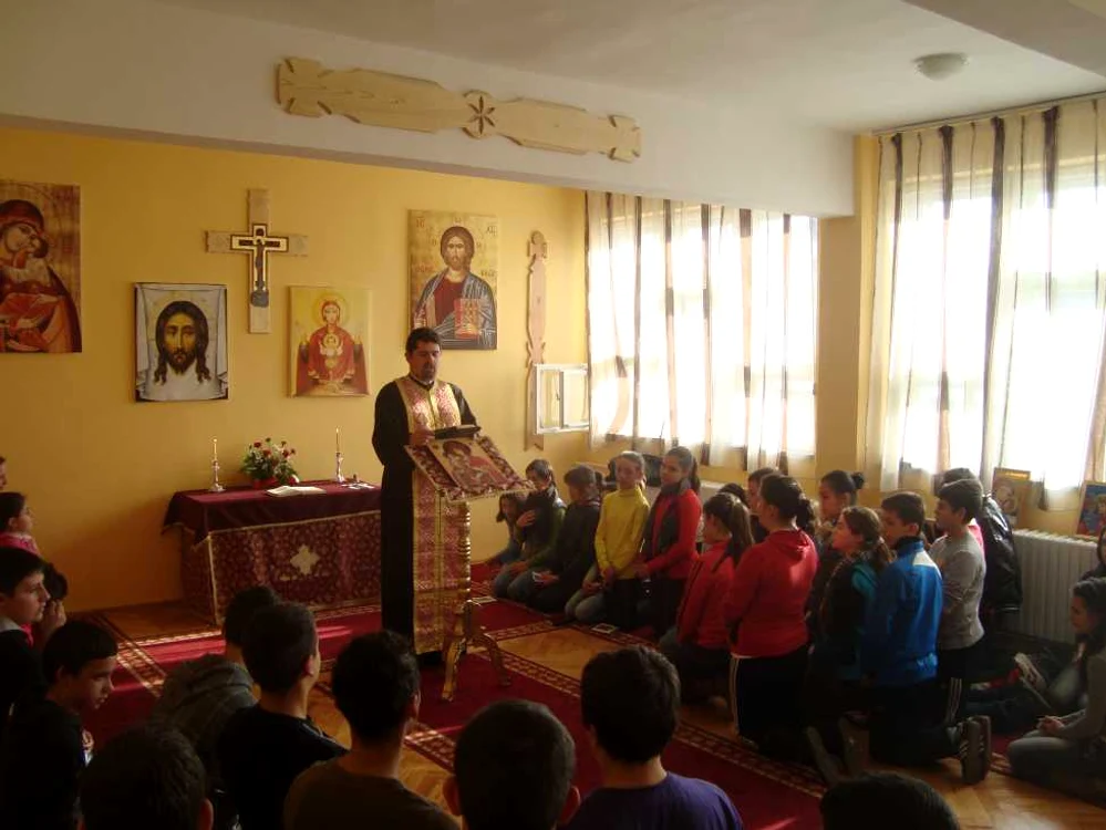 Protopopul Ciprian Taloş se roagă alături de elevii Grupului Şcolar Huedin.