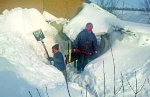 Cu ajutorul lopetilor satenii din Boboc judetul Buzau se straduiesc sa isi scoata casele de sub nameti FOTO Iulian Bunila