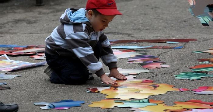 Un copil încearcă să refacă un puzzle pe aleea unui parc din Iaşi FOTO Adevărul