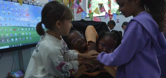 Gemenele siameze Marieme și Ndeye jucându-se cu colegele lor de școală