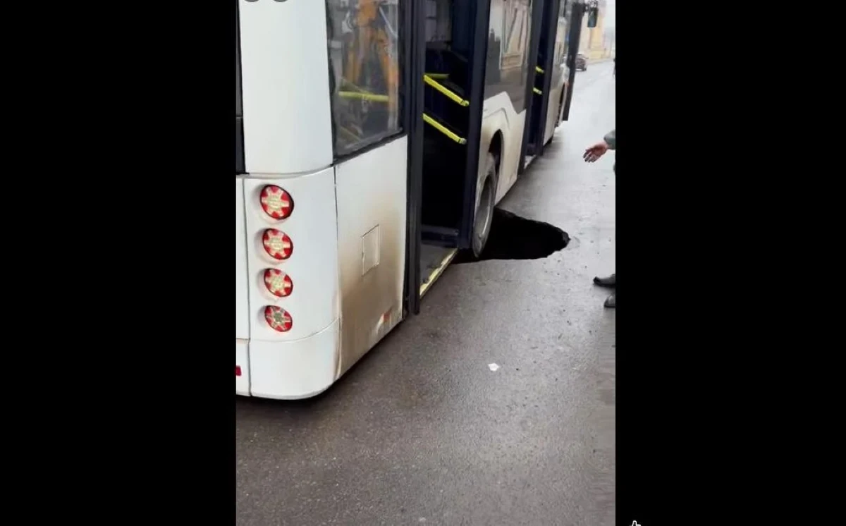 Autobuz cu pasageri, prins într-un crater apărut brusc în asfalt, pe o stradă din Brăila. „Fără macara nu-l scoate pe-ăsta...”