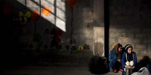 Două tinere afgane aşteaptă să fie înregistrate în centrul de înregistrare Tabakika. Mii de refugiaţi şi migranţi ajung în continuare pe ţărmurile Greciei