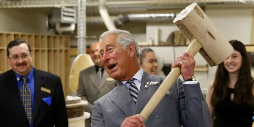 Printul Charles se joaca cu un ciocan de lemn în timpul unui turneu printr-o expoziţie de tâmplărie pentru reabilitarea patrimoniului la Colegiul Holland in Charlottetown Canda FOTO Reuters