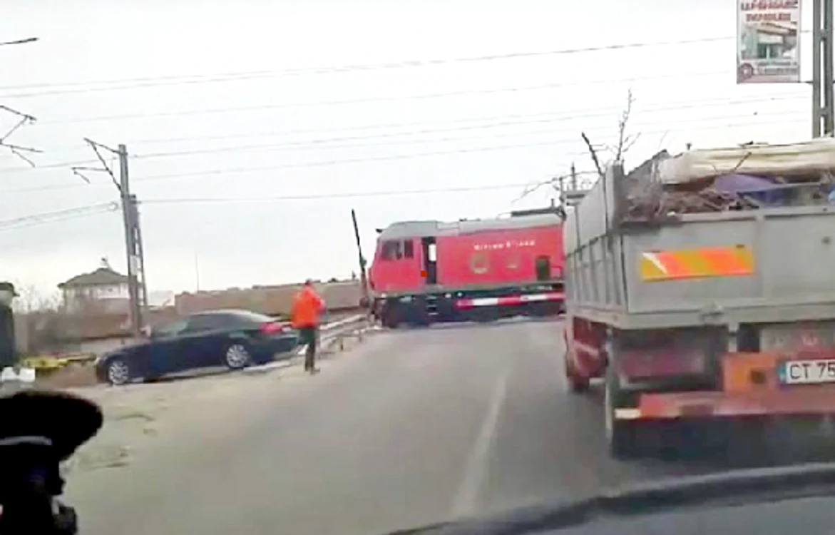 
    Mecanicul de locomotivă se grăbeşte spre tren, sub privirile şoferilor consternaţi  