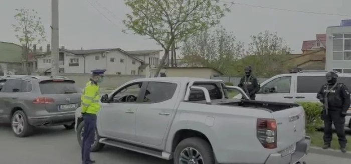 Polițistul trage pe dreapta un șofer pentru a-l verifica, sub atenta supraveghere a colegilor mascațiCaptură: IGPR