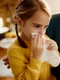 little girl blowing nose while being with her mother home jpg