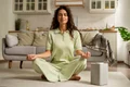 full shot woman meditating home (1) jpg