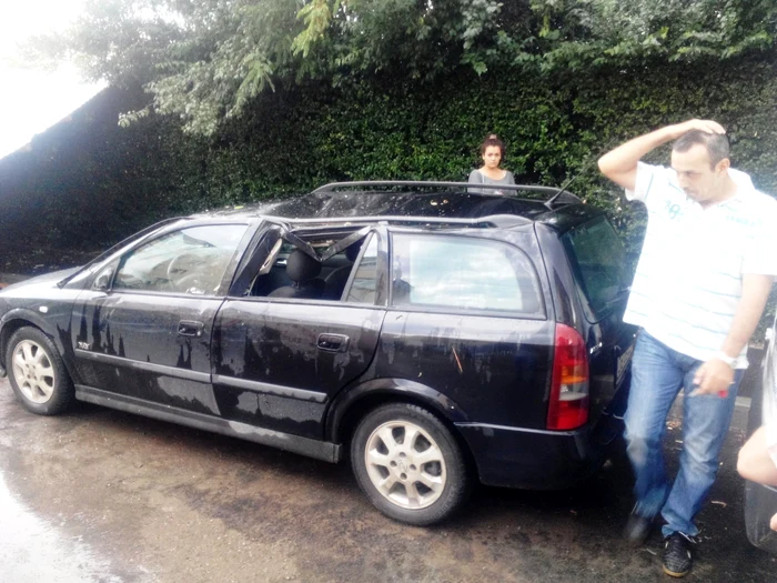 O vijelie puternică a smuls un acoperiş imens şi l-a aruncat pe două maşini