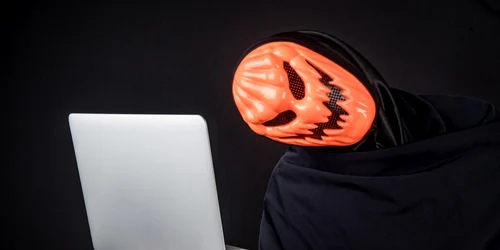 Securitate online Haloween masca laptop hacker FOTO Shutterstock