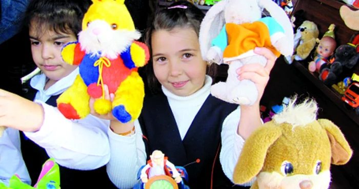 Denisa Meşter (centru) ţine la înălţime jucăriile colorate pe care le vinde cu cinci lei bucata