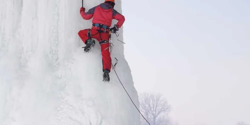 Un alpinist excaladează ţurţurele uriaş format sub podul din Iţcani