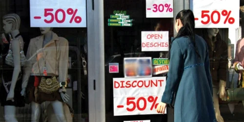 Vitrinele tapetate cu afişe care anunţă reduceri îi atrag ca un magnet pe băcăuani