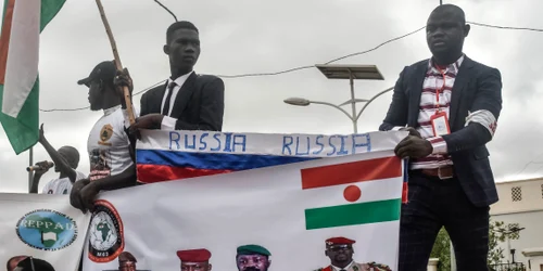 Protestatari din Niger cu steagul Rusiei si un banner cu liderii militari din Niger Mai si Burkina Faso FOTO AFP  jpg