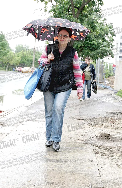 
    În faţa şantierului,  trotuarul era şi el  plin de nămol.  Liliana abia a trecut (Fotogarfii: Sever Gheorghe )  