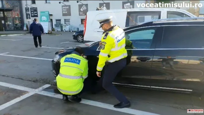 Poliţiştii lucrând pentru deblocarea maşinii din parcare FOTO Facebook