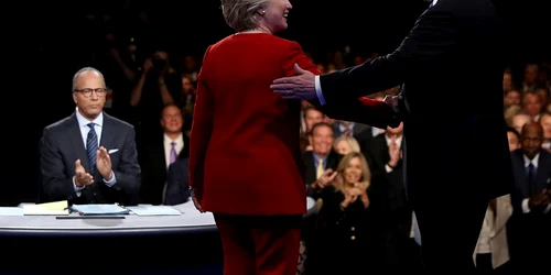 Democrata Hillary Clinton dă mâna cu candidatul la presedintie republican Donald Trump sub privirile moderatorului Lester Holt în timpul dezbaterii prezidenţiale la Universitatea Hofstra din Hempstead New York FOTO Guliver / Getty Images / Joe Raedle
