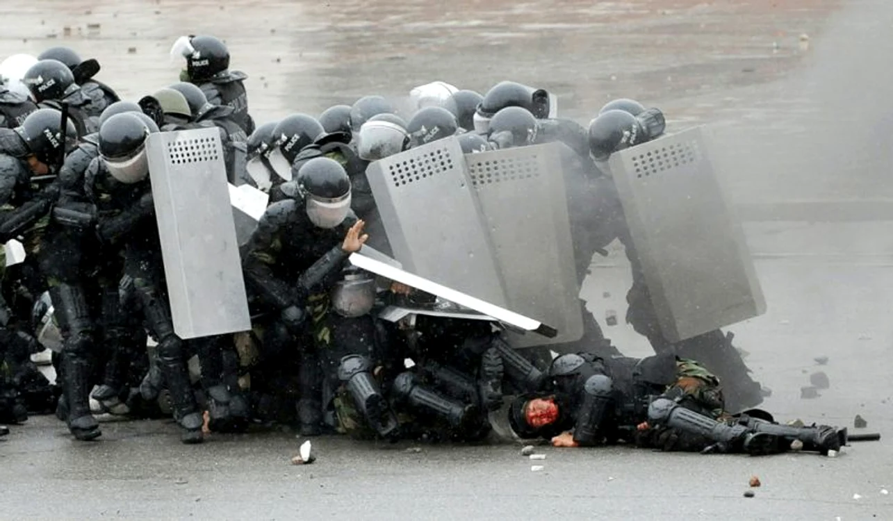 Poliţişti din Kârgâzstan încearcă se apără de atacurile manifestanţilor în timpul revoltei opoziţiei împotriva guvernului de la Bişkek, 11 aprilie (Foto: AFP / Vyacheslav Oseledko)