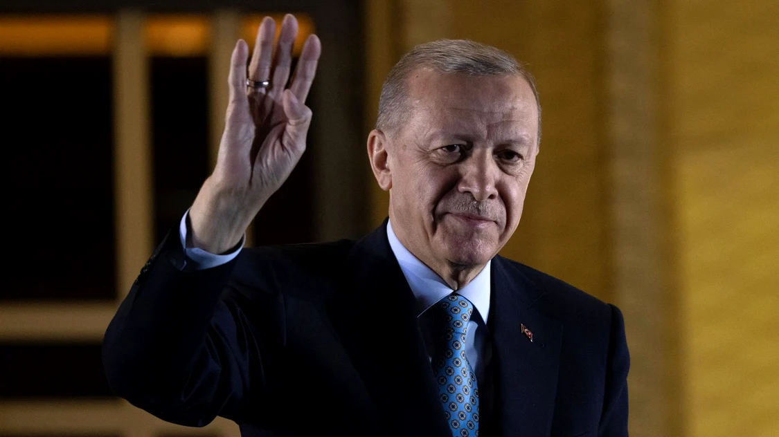 Președintele turc Recep Tayyip Erdogan cu mâna dreaptă ridicată în semn de salut