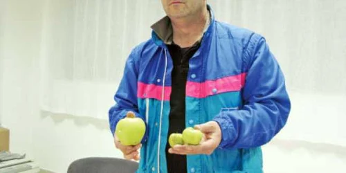 Roberto Treviziol, patronul fermei „Paradisul Înflorit“, compară un măr bun cu cele distribuite în şcoli