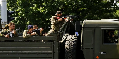 Un camion militar cu militanţii pro-ruşi inarmati trece printr-un punct de control la aeroportul din oraşul ucrainean din Doneţk FOTO Reuters