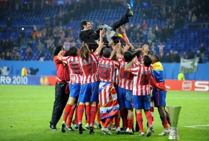 
    Jucătorii de la Atletico Madrid sărbătoresc victoria alături de antrenorul Enrique Sanchez Flores  